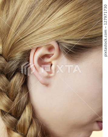 Close up on female ear and braid hair Close up on female ear and braid hair 127971730