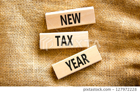 New tax year symbol. Concept words New tax year on beautiful wooden blocks. Beautiful canvas table canvas background. Business new tax year concept. Copy space. 127972228