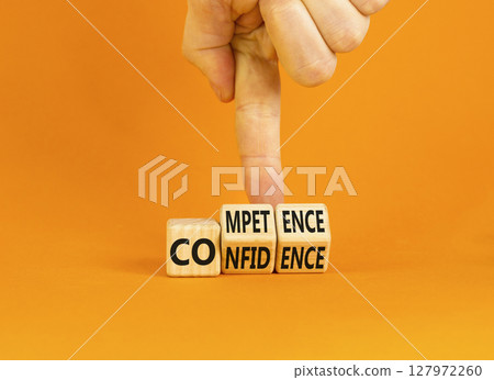 Competence and confidence symbol. Concept word Competence Confidence on wooden cubes. Businessman hand. Beautiful orange table orange background. Business competence confidence concept. Copy space. 127972260