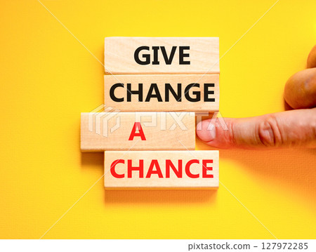 Give change a chance symbol. Concept words phrase Give change a chance on beautiful wooden blocks. Beautiful yellow paper background Businessman's hand Business Give change a chance concept Copy space 127972285
