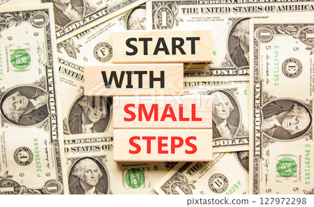 Start with small steps symbol. Concept words phrase Start with small steps on beautiful blocks. Dollar bills. Beautiful dollar bills background. Business Start with small steps concept. Copy space Start with small steps symbol. Concept words phrase Start with small steps on beautiful blocks. Dollar bills. Beautiful dollar bills background. Business Start with small steps concept. Copy space 127972298