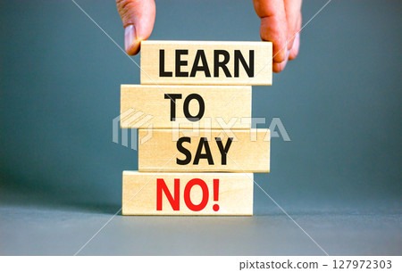 Learn to say no symbol. Concept words phrase Learn to say no on beautiful wooden blocks. Beautiful grey paper background. Businessman's hand. Business psychological Learn to say no concept. Copy space 127972303