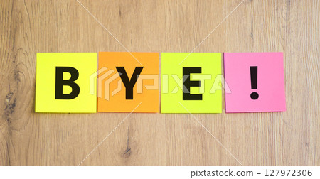 Bye symbol. Concept word Bye on beautiful colored paper. Beautiful wooden table wooden background. Business and bye concept. Copy space. 127972306
