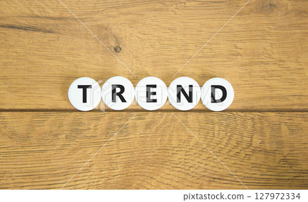 Trend and trending symbol. Concept word Trend on beautiful white circles. Beautiful wooden table wooden background. Business lifestyle trend and trending concept. Copy space. Trend and trending symbol. Concept word Trend on beautiful white circles. Beautiful wooden table wooden background. Business lifestyle trend and trending concept. Copy space. 127972334