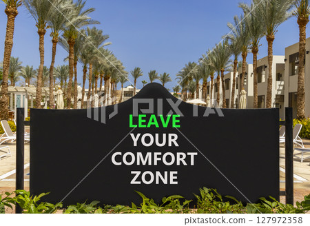 Leave your comfort zone symbol. Concept words Leave your comfort zone on beautiful road sign. Beautiful palm blue sky background. Business psychological Leave your comfort zone concept. Copy space. 127972358