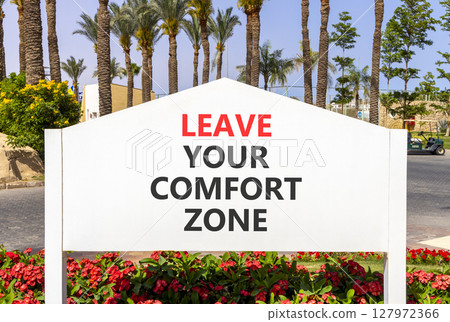 Leave your comfort zone symbol. Concept words Leave your comfort zone on beautiful road sign. Beautiful palm blue sky background. Business psychological Leave your comfort zone concept. Copy space. 127972366