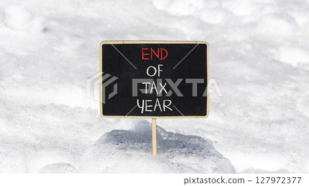 End of tax year symbol. Concept words phrase End of tax year on beautiful black blackboard. Beautiful white snow background. Business End of tax year concept. Copy space. End of tax year symbol. Concept words phrase End of tax year on beautiful black blackboard. Beautiful white snow background. Business End of tax year concept. Copy space. 127972377