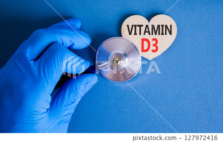Vitamin D3 symbol. Concept words Vitamin D3 on beautiful wooden heart. Doctor's hand in blue medical glove. Stethoscope. Beautiful blue background. Medical healthy lifestyle Vitamin D3 concept. Vitamin D3 symbol. Concept words Vitamin D3 on beautiful wooden heart. Doctor's hand in blue medical glove. Stethoscope. Beautiful blue background. Medical healthy lifestyle Vitamin D3 concept. 127972416