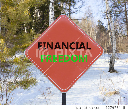 Financial freedom symbol. Concept words Financial freedom on beautiful red road sign. Beautiful forest snow blue sky background. Business financial freedom concept. Copy space. Financial freedom symbol. Concept words Financial freedom on beautiful red road sign. Beautiful forest snow blue sky background. Business financial freedom concept. Copy space. 127972446