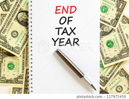 End of tax year symbol. Concept words phrase End of tax year on beautiful white note. Dollar bills. Beautiful dollar bills background. Business End of tax year concept. Copy space. End of tax year symbol. Concept words phrase End of tax year on beautiful white note. Dollar bills. Beautiful dollar bills background. Business End of tax year concept. Copy space. 127972450