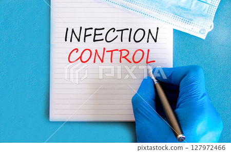 Infection control symbol. Concept words Infection control on beautiful white note. Doctor's hand in blue medical glove. Beautiful blue background. Medical healthy lifestyle infection control concept. 127972466