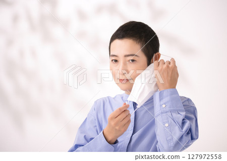 Middle-aged woman removing mask 127972558