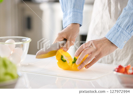 Hands of a young man cutting vegetables Hands of a young man cutting vegetables 127972994