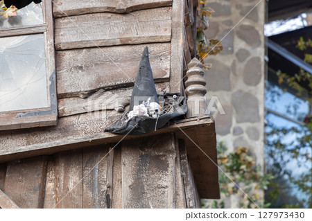 Old wooden house with broken glass in the window. Halloween concept Old wooden house with broken glass in the window. Halloween concept 127973430
