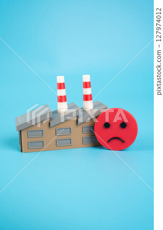 Industrial plant and sad face. Deteriorating financial situation and low expectations from forecasts. Pessimism in industrial sectors. Reduced investor confidence. Industrial plant and sad face. Deteriorating financial situation and low expectations from forecasts. Pessimism in industrial sectors. Reduced investor confidence. 127974012