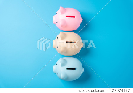 Multicolored piggy banks for savings. Distribution of savings and investments across different economic instruments. Financial diversification. Stocks, bonds, deposits, and pensions. 127974137