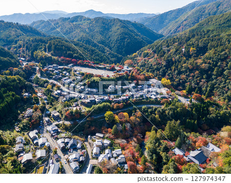 Aerial view of Takao, where the Arashiyama Takao Parkway runs. Below you can see Jingoji Temple and the mountain villages dyed in autumn colors. Ukyo Ward, Kyoto City, Kyoto 127974347