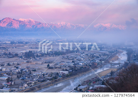 The Northern Alps bathed in the morning sun and the Matsumoto Basin shrouded in morning mist [Photo taken from Shiroyama Park Observatory] 127974564