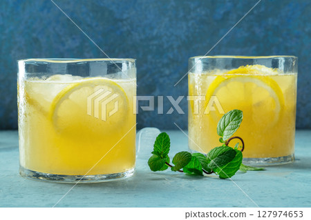 Glasses of lemonade with mint, a mocktail with lemon juice, on a blue background 127974653