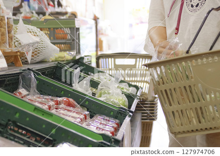 A woman shopping at the vegetable corner of a supermarket 127974706