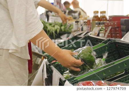 A woman shopping at the vegetable corner of a supermarket 127974709