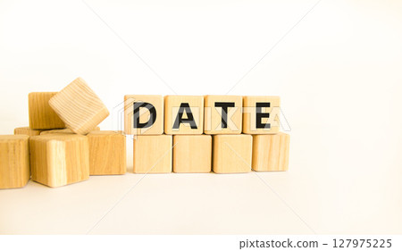 Date symbol. Concept word Date on beautiful wooden blocks. Beautiful white table white background. Business and date concept. Copy space. Date symbol. Concept word Date on beautiful wooden blocks. Beautiful white table white background. Business and date concept. Copy space. 127975225
