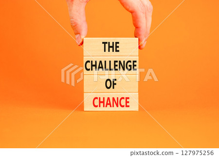 The challenge of chance symbol. Concept words phrase The challenge of chance on beautiful wooden blocks. Beautiful orange paper background. Business The challenge of chance concept. Copy space. 127975256