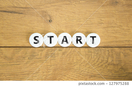 Start symbol. Concept word Start on beautiful white pills circles. Beautiful wooden table wooden background. Business lifestyle start concept. Copy space. 127975288