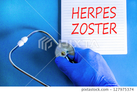 Herpes zoster symbol. Concept words Herpes zoster on beautiful white note. Doctor's hand in blue medical glove. Stethoscope. Beautiful blue background. Medical healthy lifestyle herpes zoster concept 127975374