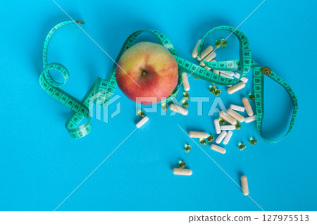 Weight Loss Pills and Measuring Tape, Diet Supplements Capsules, Obesity Lose Tablets, Color Drugs Pile 127975513