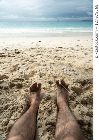 Bare feet resting in warm sand on tropical beach, symbolizing summer relaxation, freedom Bare feet resting in warm sand on tropical beach, symbolizing summer relaxation, freedom 127975569