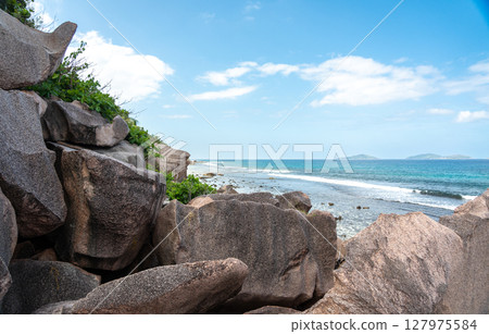 View from rocky granite coastline of La Digue Island, Seychelles, overlooking the ocean 127975584