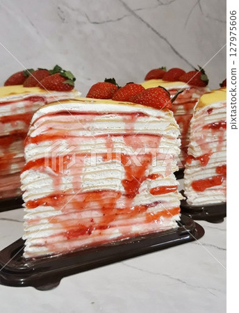 Delicate layers of soft crepes and light pastry cream stacked into a melt in your mouth slice. A refined dessert with a perfect balance of texture and sweetness. 127975606
