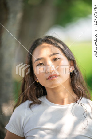 Portrait of a young woman relaxing in the sunlight 127975767