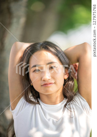 一位年輕女子在陽光下放鬆的肖像 127975768