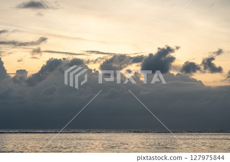 Cloud layers above calm sea reflect soft light at dusk near La Digue island, Seychelles Cloud layers above calm sea reflect soft light at dusk near La Digue island, Seychelles 127975844