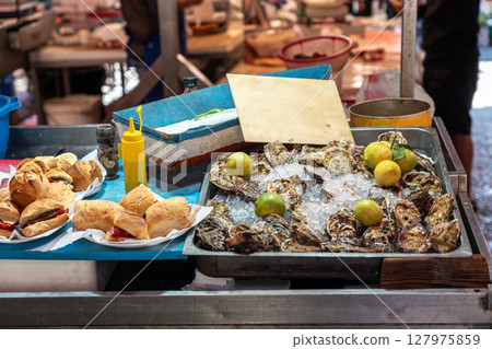 Fresh oysters and sandwiches at seafood market stall 127975859