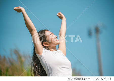 年輕女子在藍天下放鬆 127976041