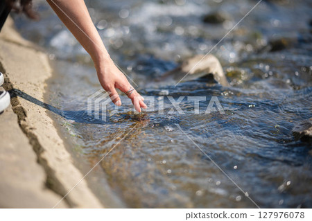 Young woman relaxing by the river 127976078