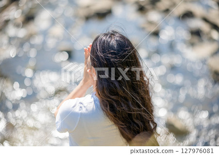 Young woman relaxing by the river 127976081