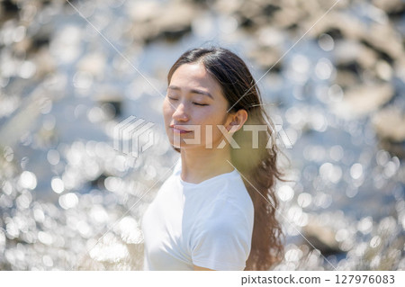 Young woman relaxing by the river 127976083