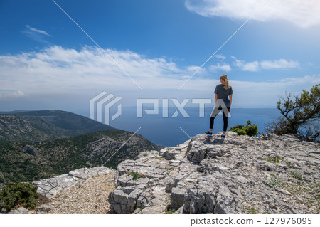 Young woman hiking on a cliff and views of the Adriatic Sea Young woman hiking on a cliff and views of the Adriatic Sea 127976095