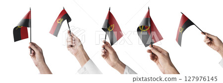 The Angola flag in hand in different angles on a white background The Angola flag in hand in different angles on a white background 127976145
