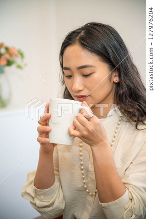 年輕女子在室內放鬆並喝一杯 127976204