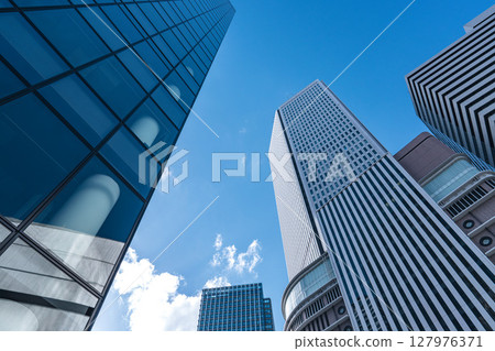 仰望藍天,被摩天大樓包圍的城市景觀 仰望藍天,被摩天大樓包圍的城市景觀 127976371
