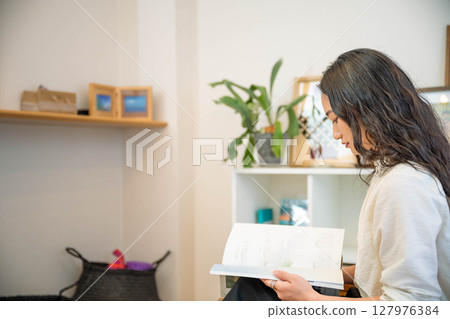 年輕女子在室內放鬆看書 127976384