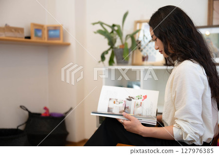 年輕女子在室內放鬆看書 127976385