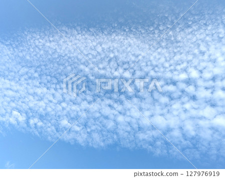 Pretty blue sky with bubble style white clouds floating atmosphere gentle skyscape 127976919