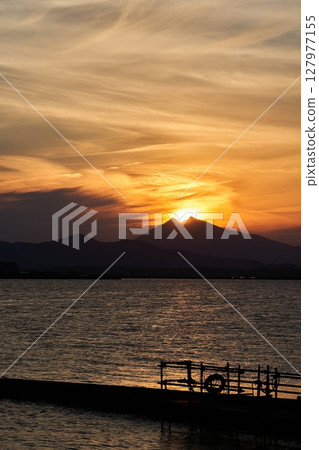 Mt.Tsukuba seen from Lake Kasumigaura at dusk and the sun on its summit 127977155
