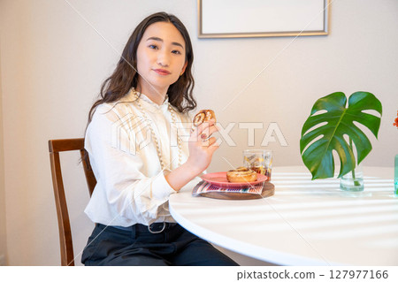 A young woman happily eating bread A young woman happily eating bread 127977166